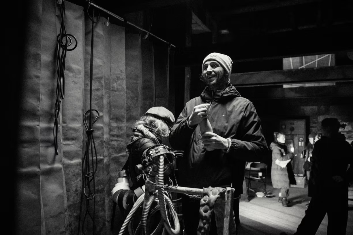 Cameron Richards directing on set, in black and white.
