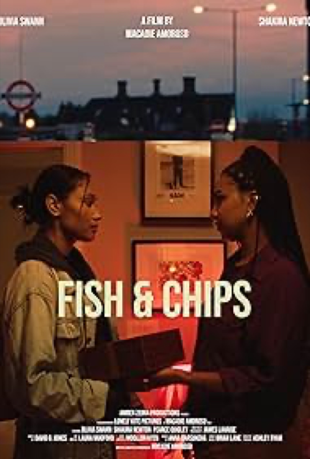 Still from Fish & Chips: two women talking inside a chip shop at dusk.